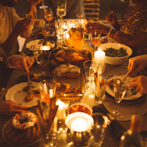 Eine Festtafel bei Kerzenlicht mit Menschen die beim Essen sind